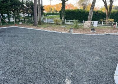Terrassement et empierrement d’accès en gravier concassé - JÉROME TP Aire de stationnement préparée en gravier concassé avec bordures, lors d’un chantier de terrassement par JÉROME TP.