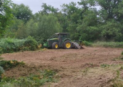 Débroussaillage mécanique de haies avec mini-pelle équipée d’un broyeur - JÉROME TP Mini-pelle JÉROME TP effectuant la coupe d’une haie haute à l’aide d’un broyeur débroussailleur hydraulique.